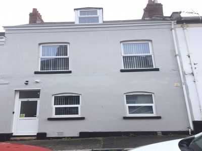 Light grey terrace front with a white door and a dormer in the roof